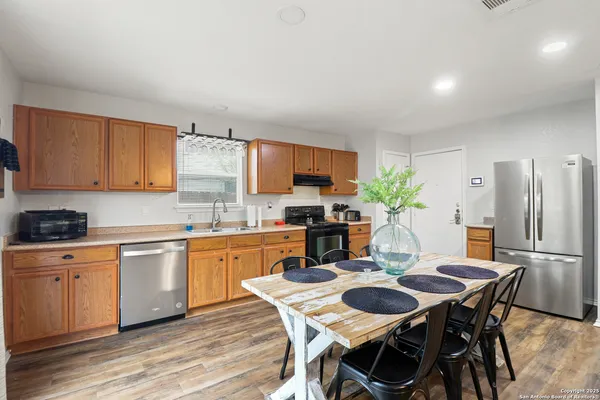 a kitchen with stainless steel appliances kitchen island granite countertop a dining table chairs and granite counter tops
