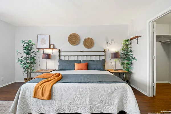 a bedroom with a bed and a potted plant