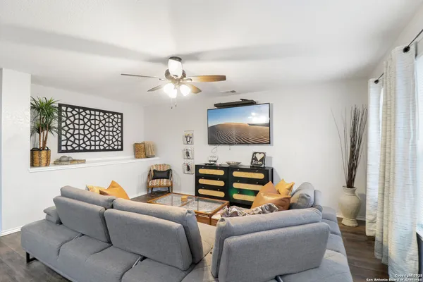 a living room with furniture a flat screen tv and a window