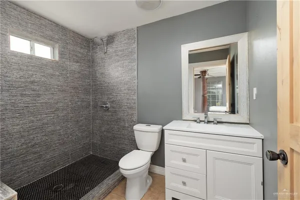 a bathroom with a toilet sink vanity and mirror
