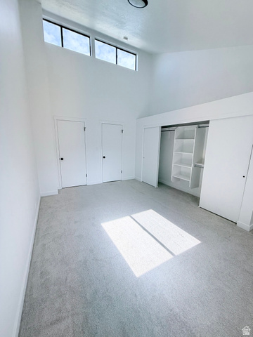 227 South West Lane Provo, UT 84601 - Photo 12 of 25 Spacious room featuring a vaulted ceiling with clerestory windows, light gray carpeting, and a built-in closet system with shelving