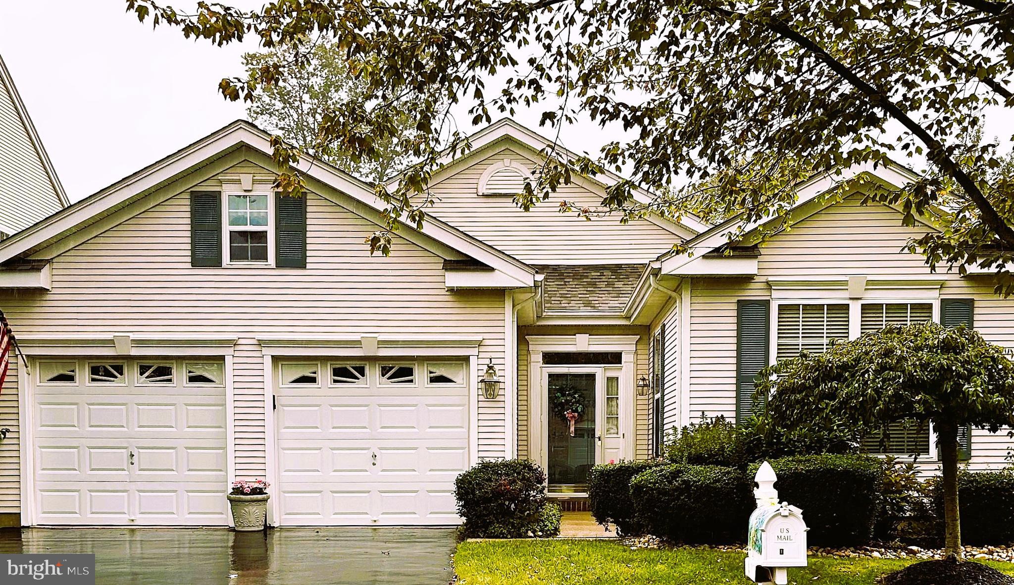 a front view of a house with yard garage and glass windows
