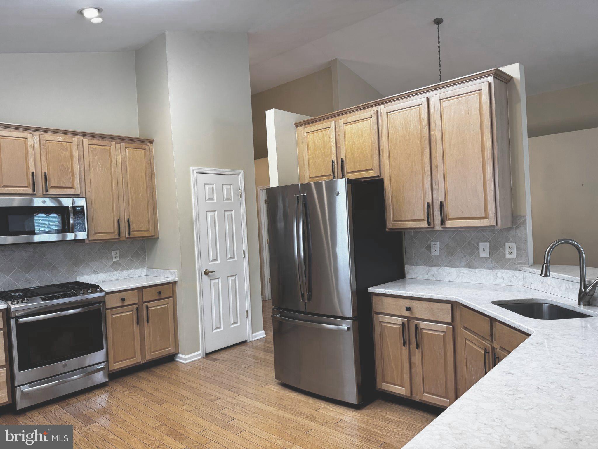 10 Powderhorn Way Allentown, NJ 08501 - Photo 11 of 42 a kitchen with stainless steel appliances granite countertop a refrigerator a sink dishwasher a stove and a microwave oven with wooden floor