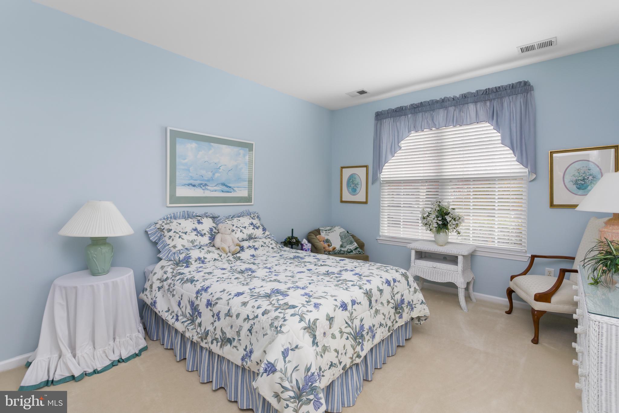 10 Powderhorn Way Allentown, NJ 08501 - Photo 20 of 44 a bedroom with a bed and a lamp on table