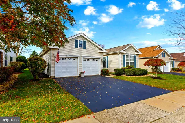 a view of a white house with a yard and plants