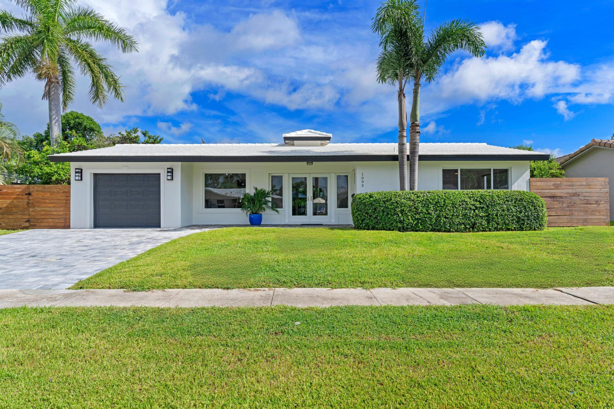 1093 Southwest 14th Street Boca Raton, FL 33486 - Photo 1 of 18 a front view of a house with a garden