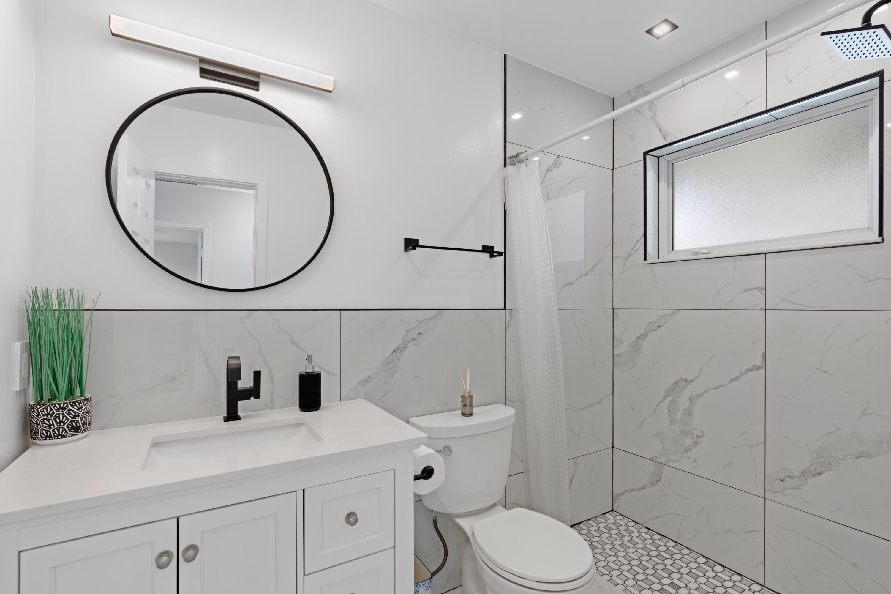 1093 Southwest 14th Street Boca Raton, FL 33486 - Photo 12 of 18 a bathroom with a sink a toilet and a mirror