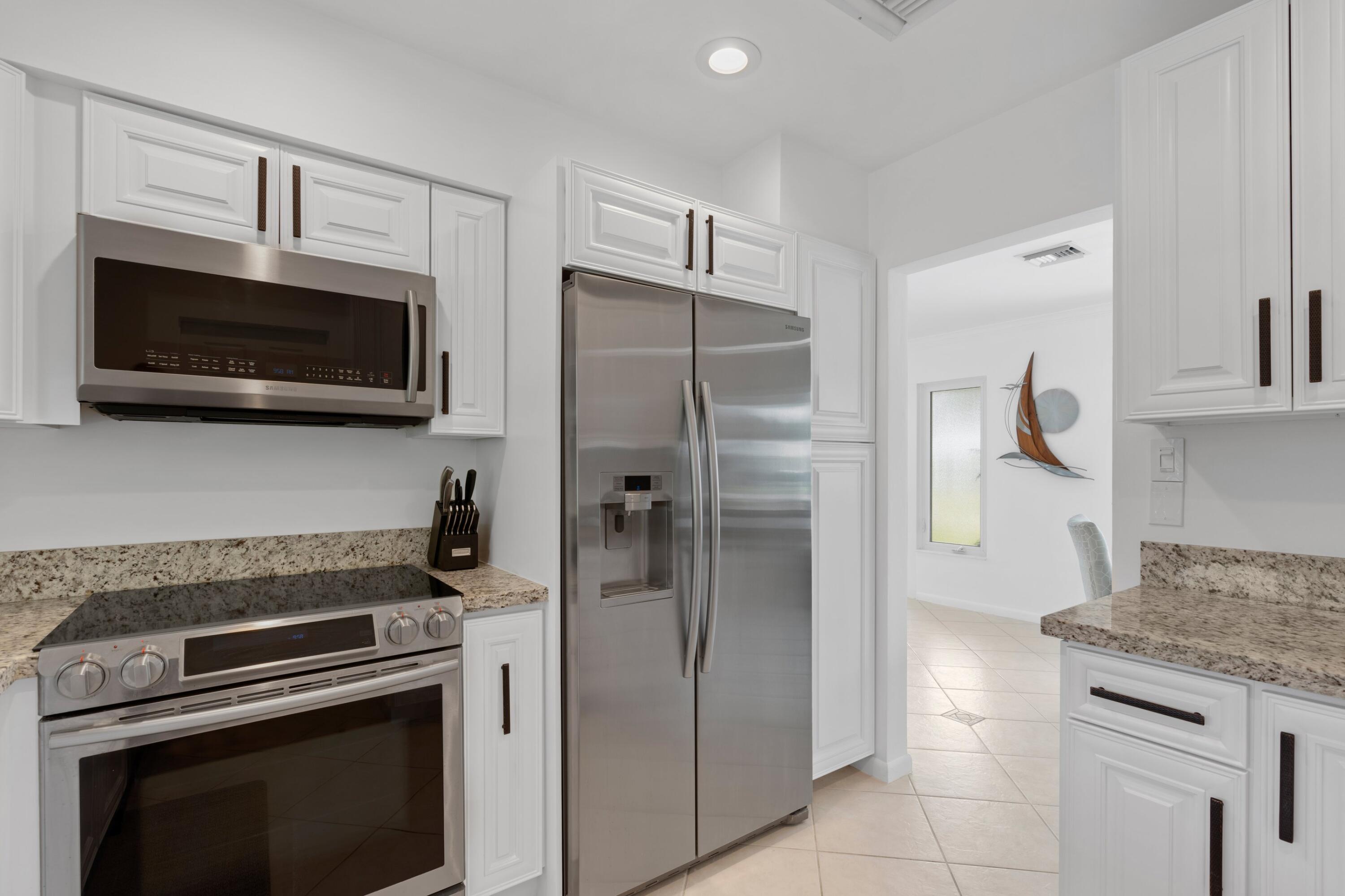 1093 Southwest 14th Street Boca Raton, FL 33486 - Photo 8 of 18 a kitchen with stainless steel appliances granite countertop a refrigerator stove and microwave