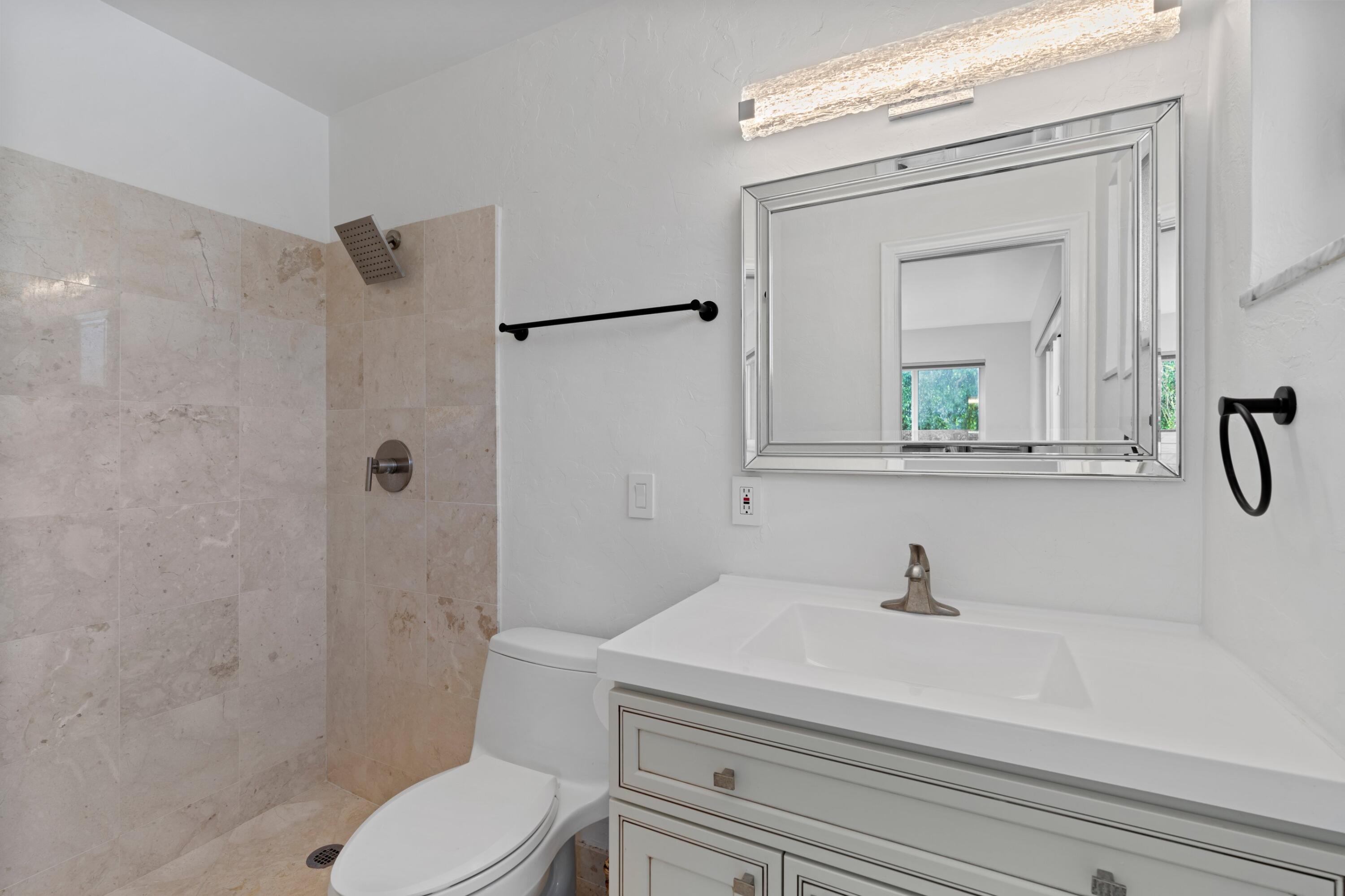 1093 Southwest 14th Street Boca Raton, FL 33486 - Photo 10 of 18 a bathroom with a sink a toilet and a mirror