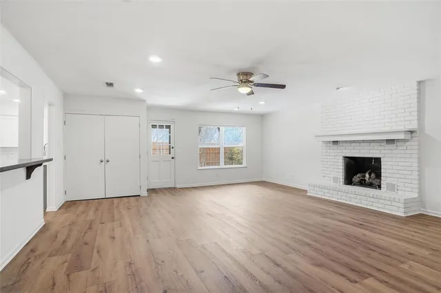 a view of an empty room with a fireplace and a window