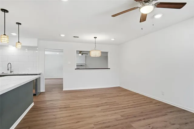 a view of a kitchen with a sink wooden floor and a chandelier