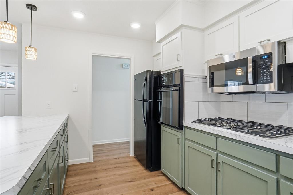 1236 Terrace Drive Grapevine, TX 76051 - Photo 9 of 25 a kitchen with stainless steel appliances granite countertop a refrigerator a stove and a sink with wooden floor