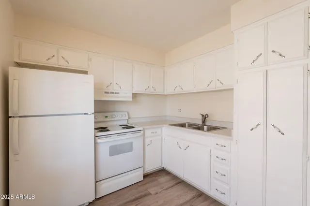 a kitchen with appliances a sink and cabinets