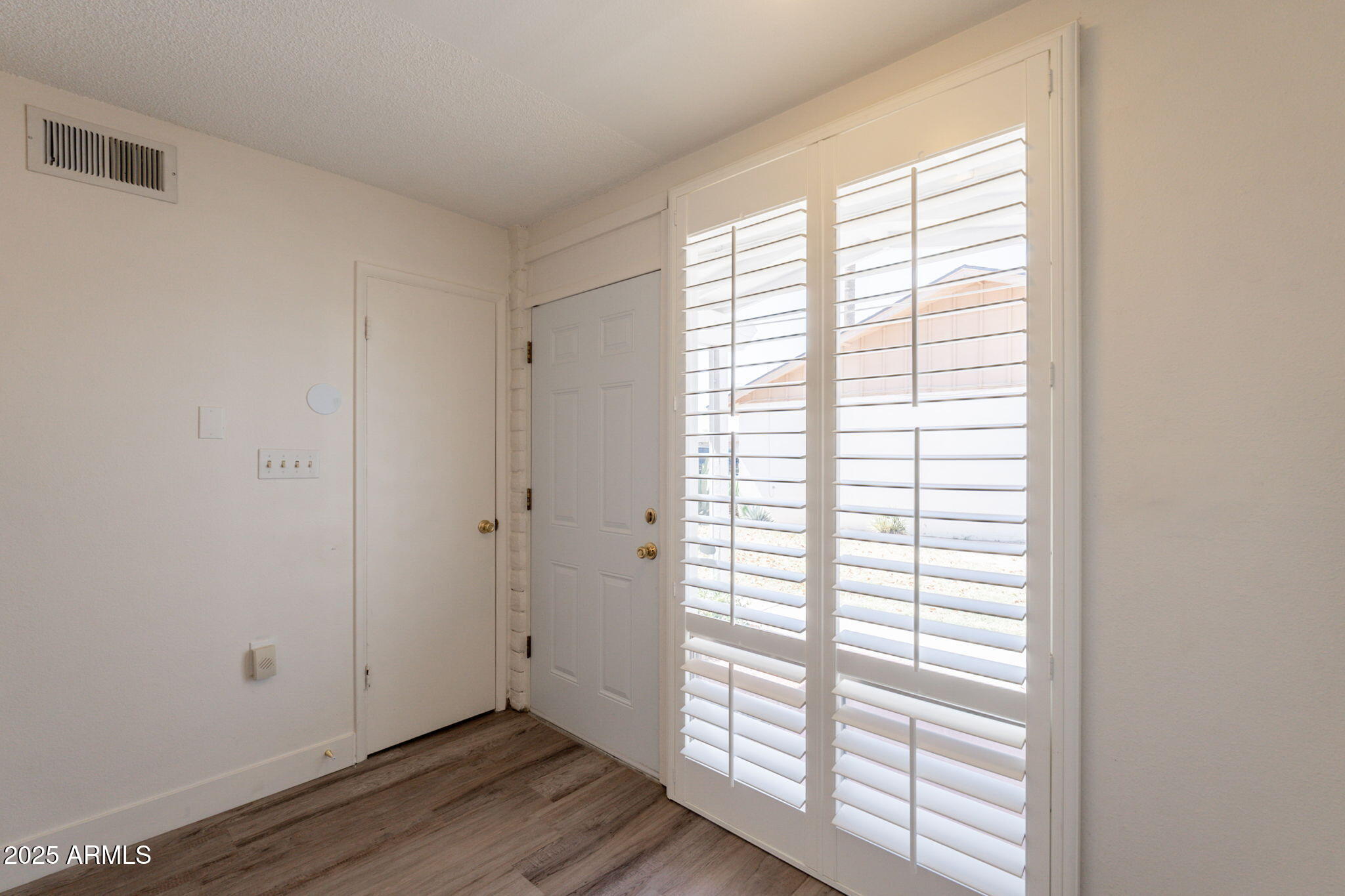 13001 North 113th Avenue, Unit 5 Youngtown, AZ 85363 - Photo 15 of 36 a view of an empty room with wooden floor and a window