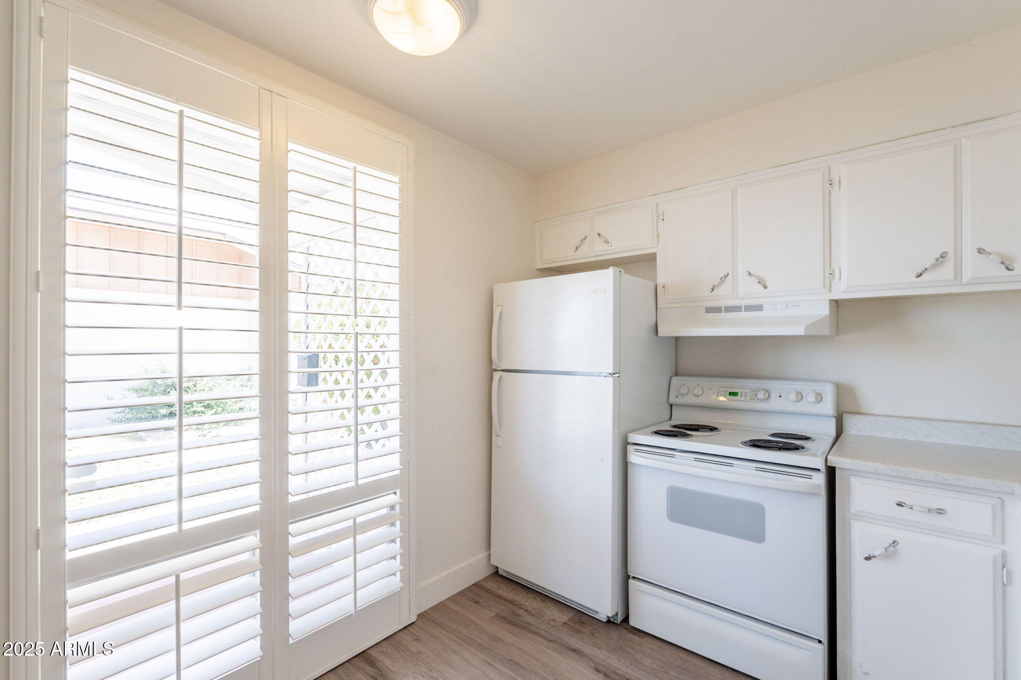 13001 North 113th Avenue, Unit 5 Youngtown, AZ 85363 - Photo 16 of 36 a kitchen with a white cabinets and white appliances