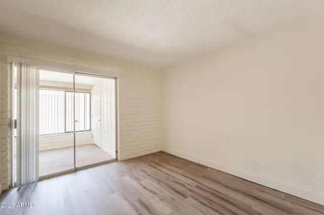 an empty room with wooden floor and sliding door