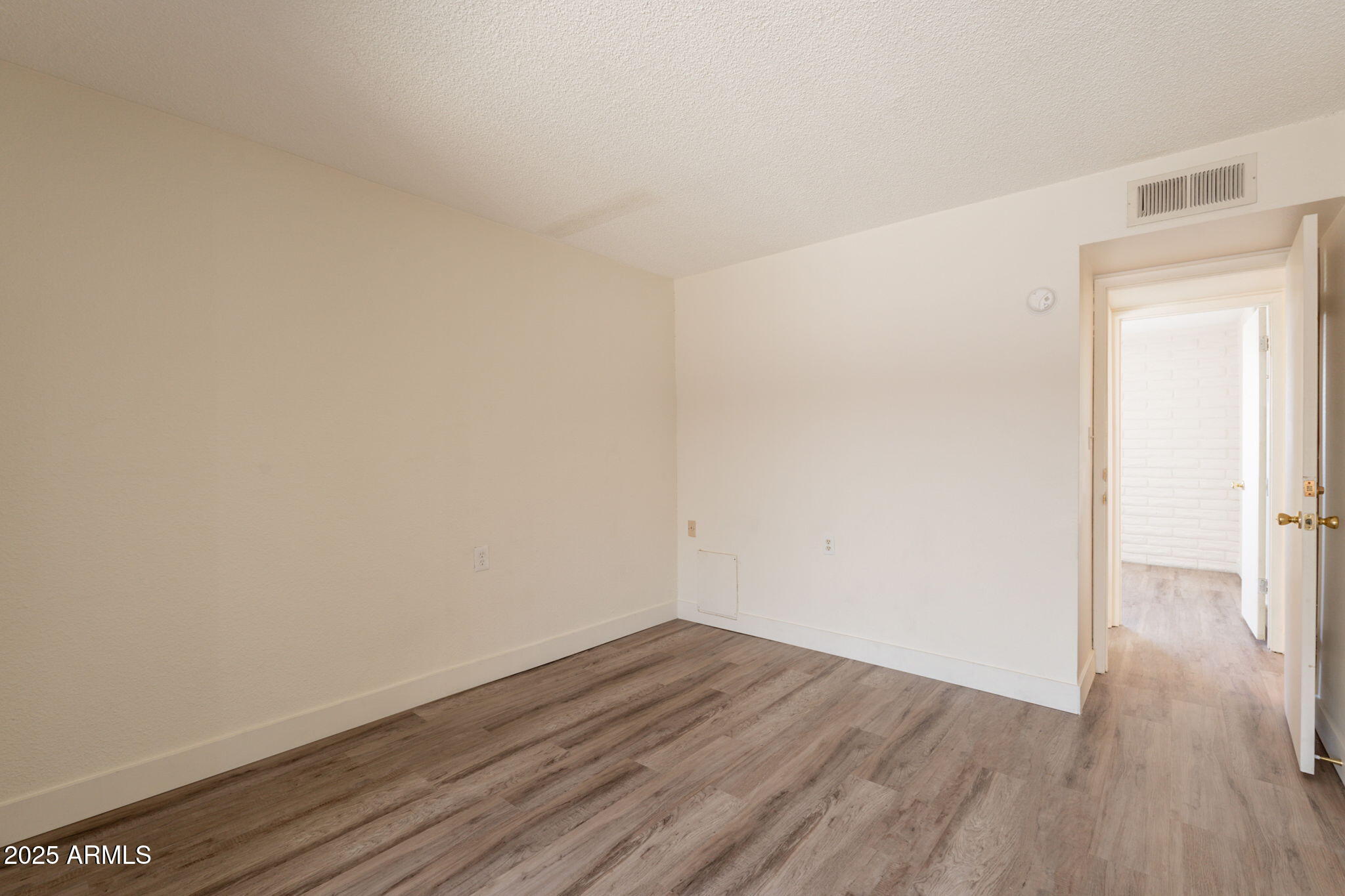 13001 North 113th Avenue, Unit 5 Youngtown, AZ 85363 - Photo 18 of 36 a view of an empty room with wooden floor