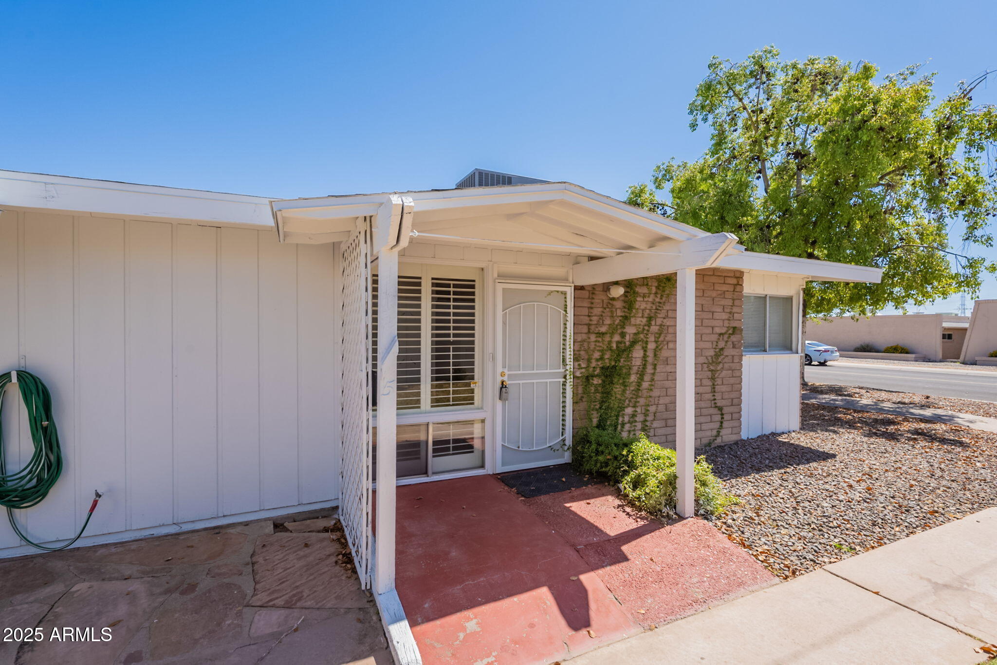 13001 North 113th Avenue, Unit 5 Youngtown, AZ 85363 - Photo 2 of 36 a front view of a house with garden