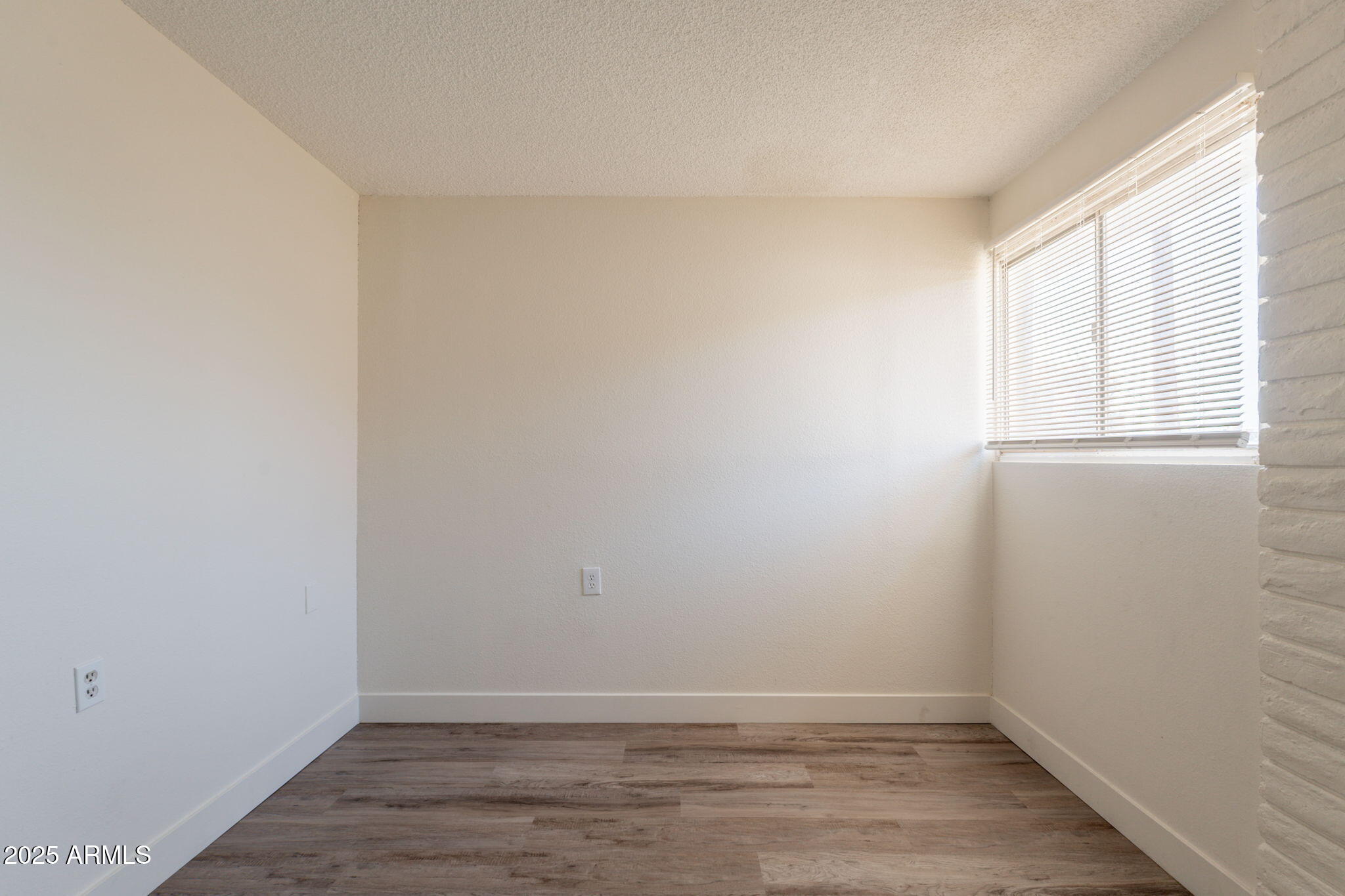 13001 North 113th Avenue, Unit 5 Youngtown, AZ 85363 - Photo 24 of 36 a view of an empty room with wooden floor and a window