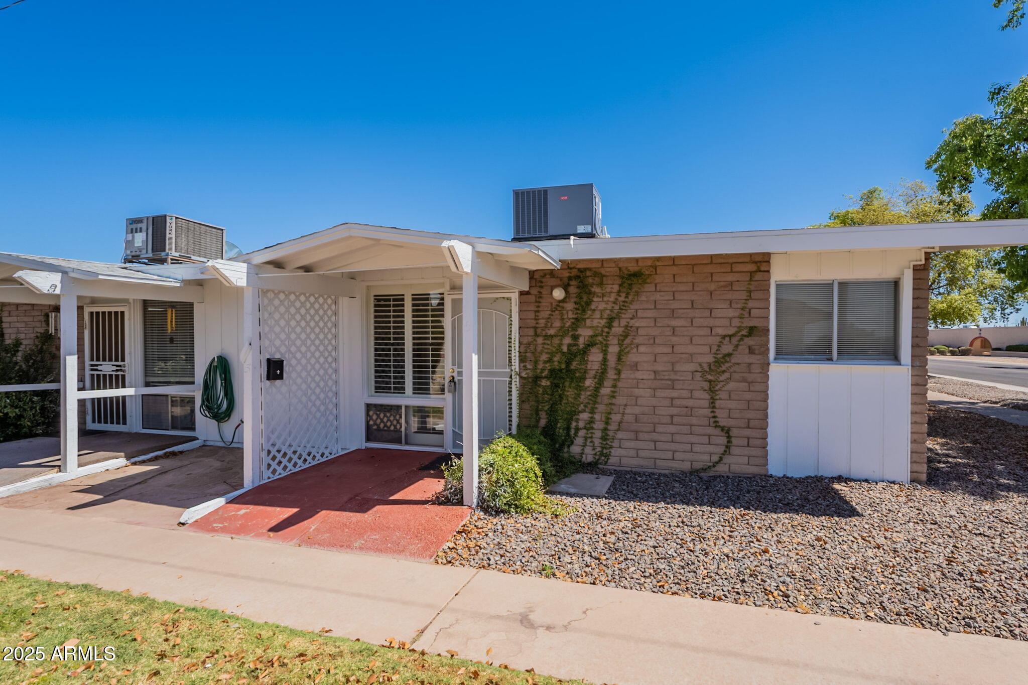 13001 North 113th Avenue, Unit 5 Youngtown, AZ 85363 - Photo 3 of 36 a front view of a house with garden