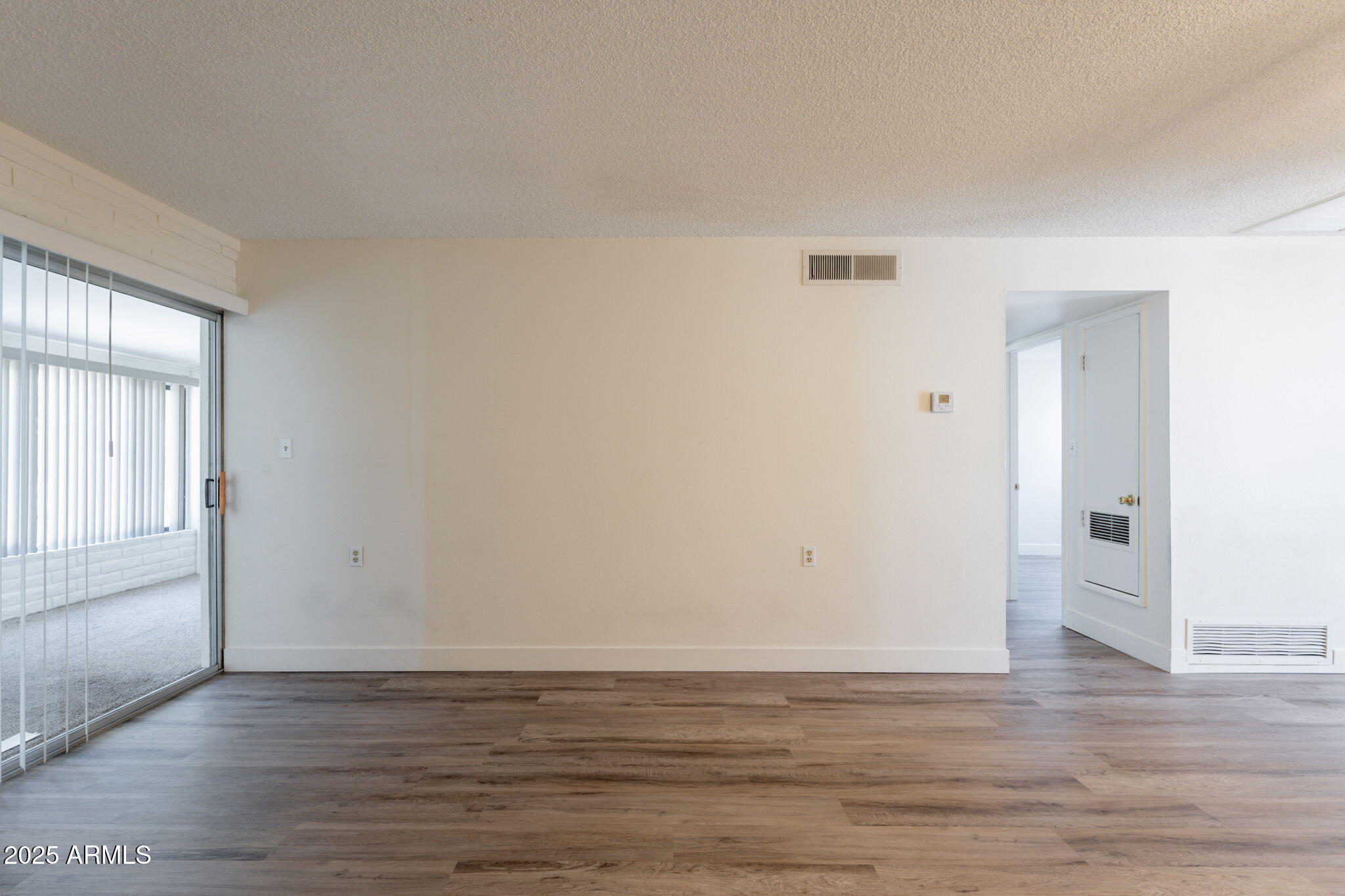 13001 North 113th Avenue, Unit 5 Youngtown, AZ 85363 - Photo 7 of 36 a view of an empty room with wooden floor and a window