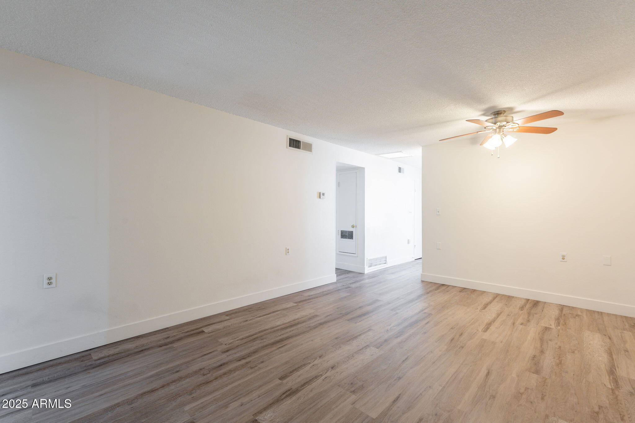 13001 North 113th Avenue, Unit 5 Youngtown, AZ 85363 - Photo 8 of 36 a view of an empty room with wooden floor