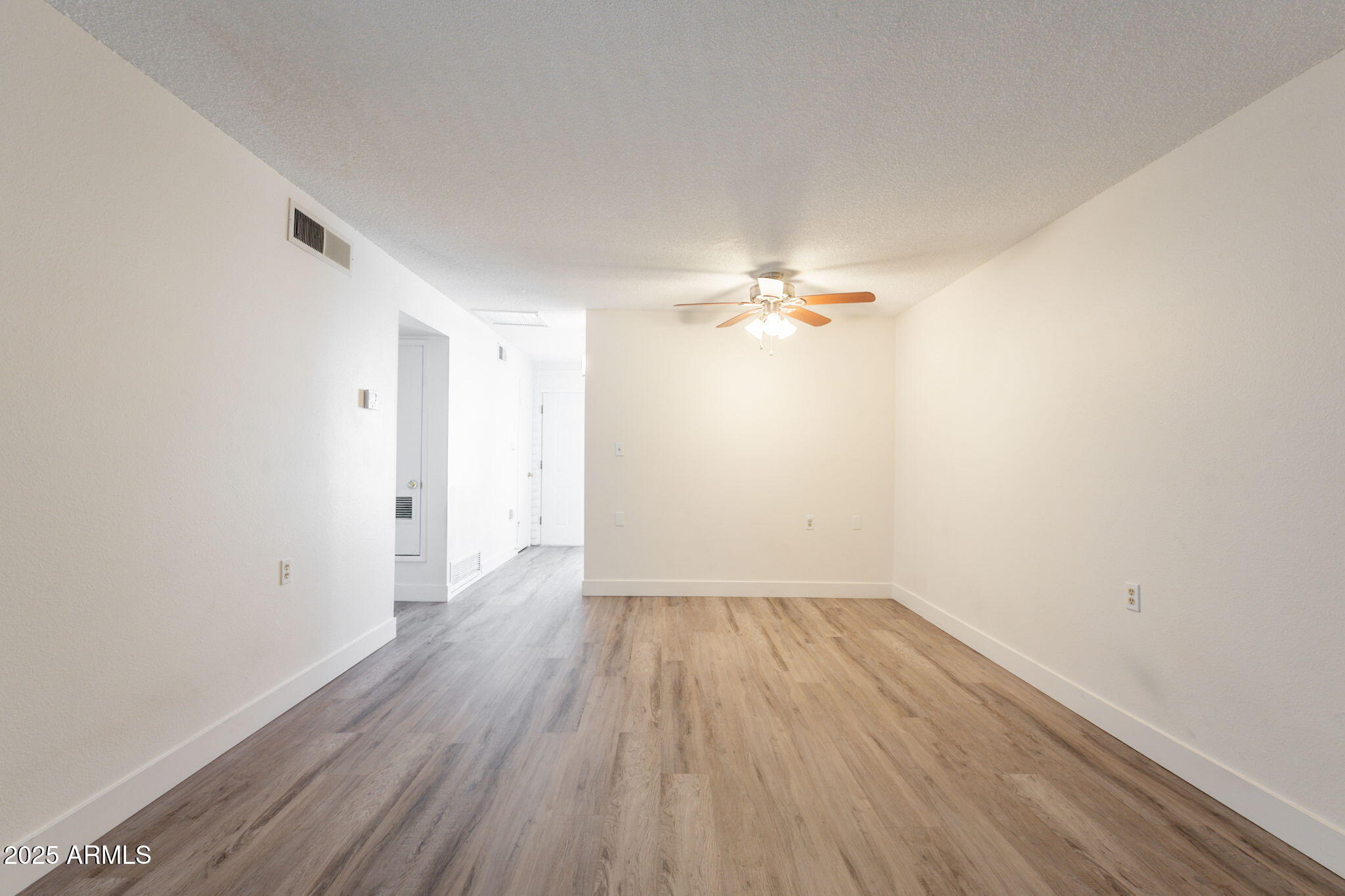 13001 North 113th Avenue, Unit 5 Youngtown, AZ 85363 - Photo 9 of 36 a view of a room with wooden floor and white walls