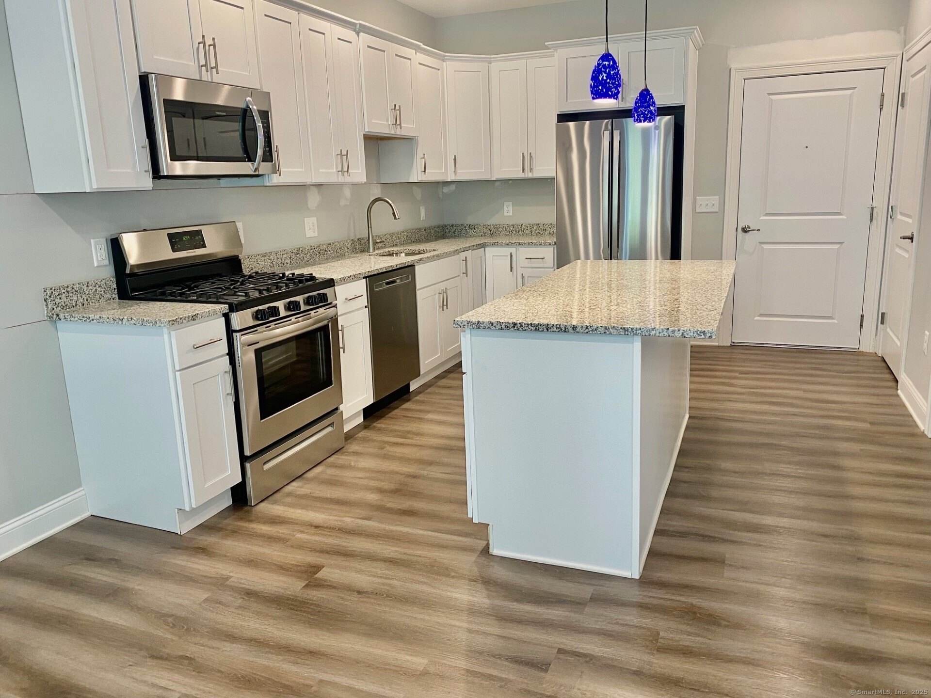 5 Cherry Brook Road, Unit 121 Canton, CT 06019 - Photo 5 of 10 a kitchen with granite countertop a stove top oven and cabinets