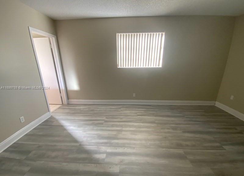 4308 Adams Street Hollywood, FL 33021 - Photo 11 of 21 an empty room with wooden floor and windows