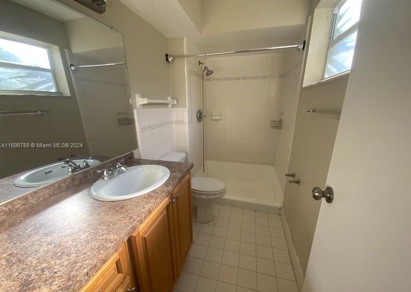 4308 Adams Street Hollywood, FL 33021 - Photo 13 of 21 a bathroom with a granite countertop sink a toilet and shower