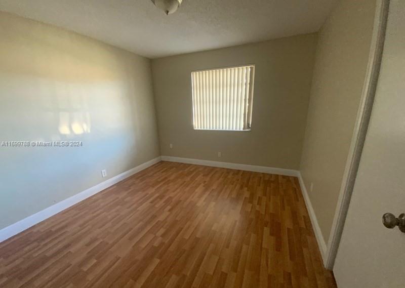 4308 Adams Street Hollywood, FL 33021 - Photo 15 of 21 an empty room with wooden floor and windows