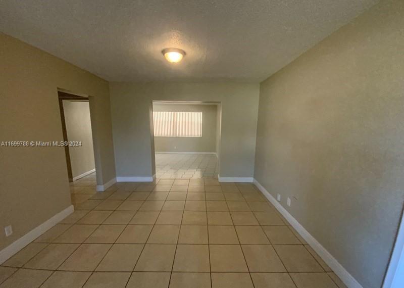 4308 Adams Street Hollywood, FL 33021 - Photo 4 of 21 an empty room with white walls and tiles