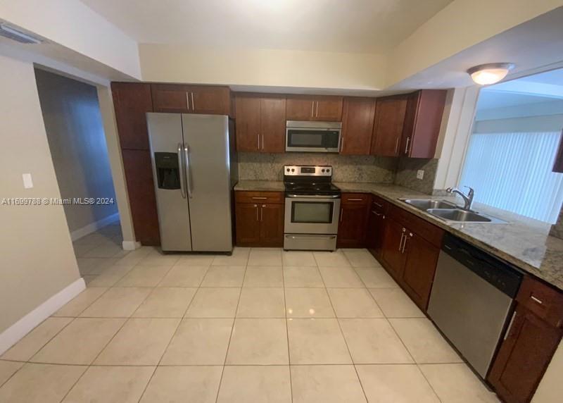 4308 Adams Street Hollywood, FL 33021 - Photo 7 of 21 a large kitchen with stainless steel appliances granite countertop a refrigerator and a sink