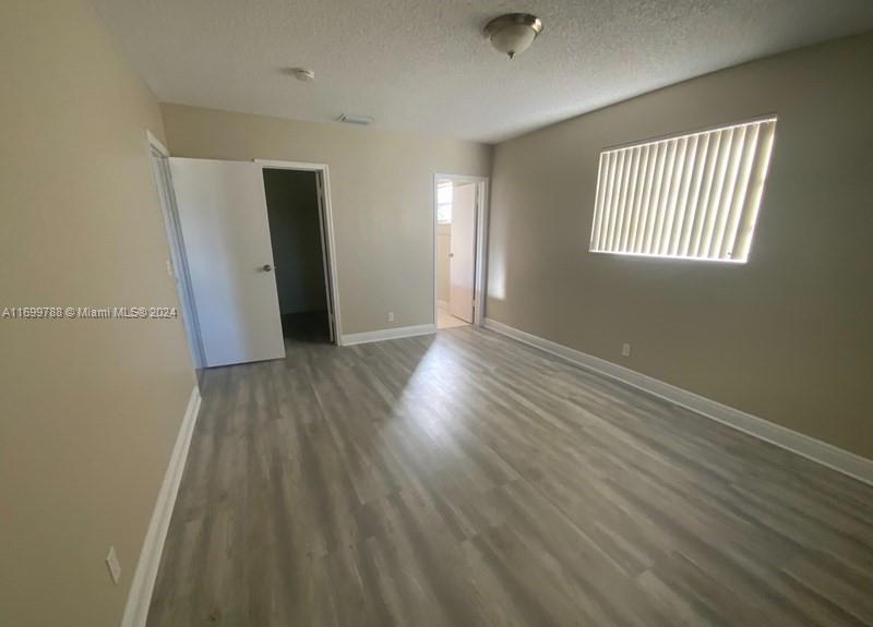 4308 Adams Street Hollywood, FL 33021 - Photo 10 of 21 an empty room with wooden floor and windows