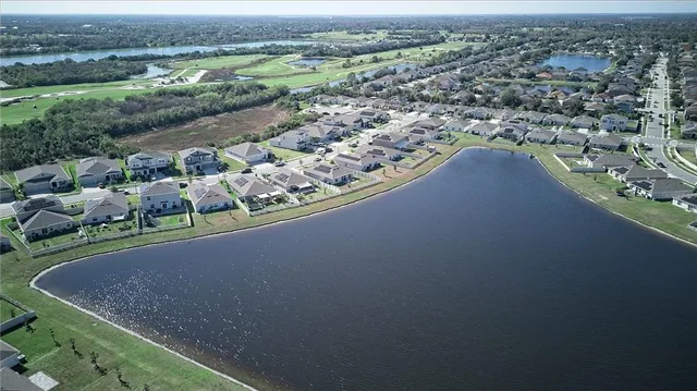 an aerial view of a house with a yard and lake view