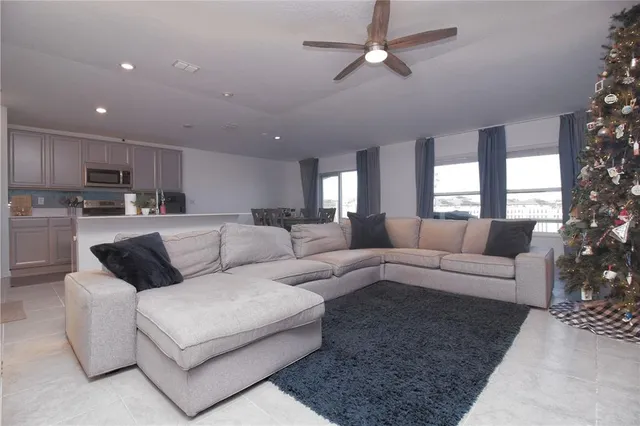 a living room with furniture and a view of kitchen