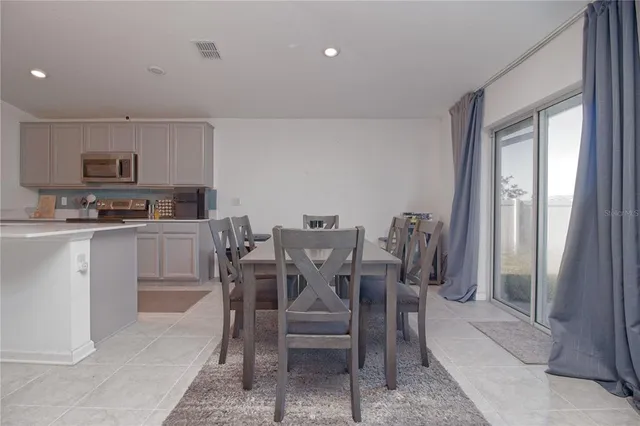 a view of a dining room with furniture and a kitchen