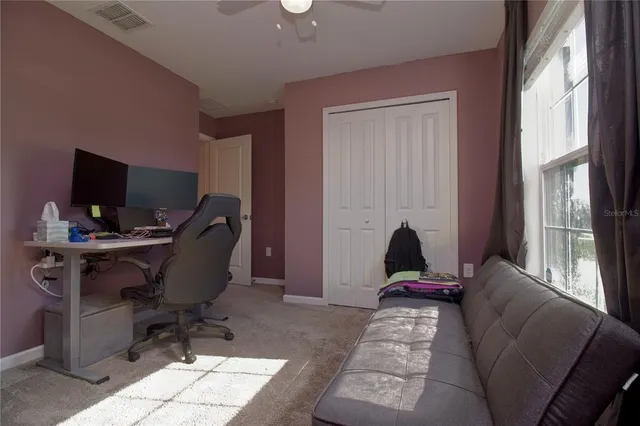 a view of a workspace with furniture and a window