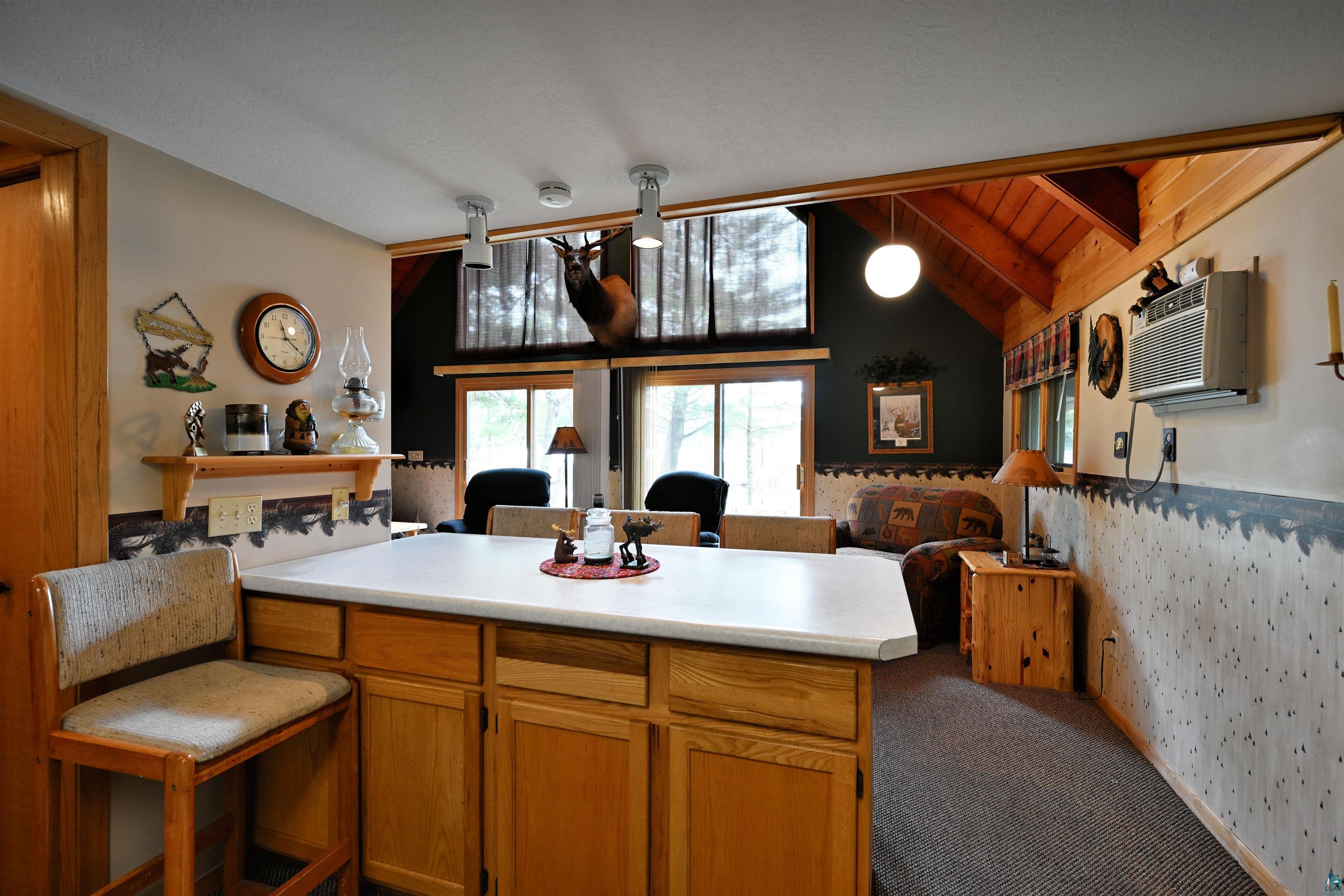2775 Lake Road Barnes, WI 54873 - Photo 52 of 52 Kitchen featuring open floor plan, light countertops, dark colored carpet, lofted ceiling with beams, and wooden ceiling