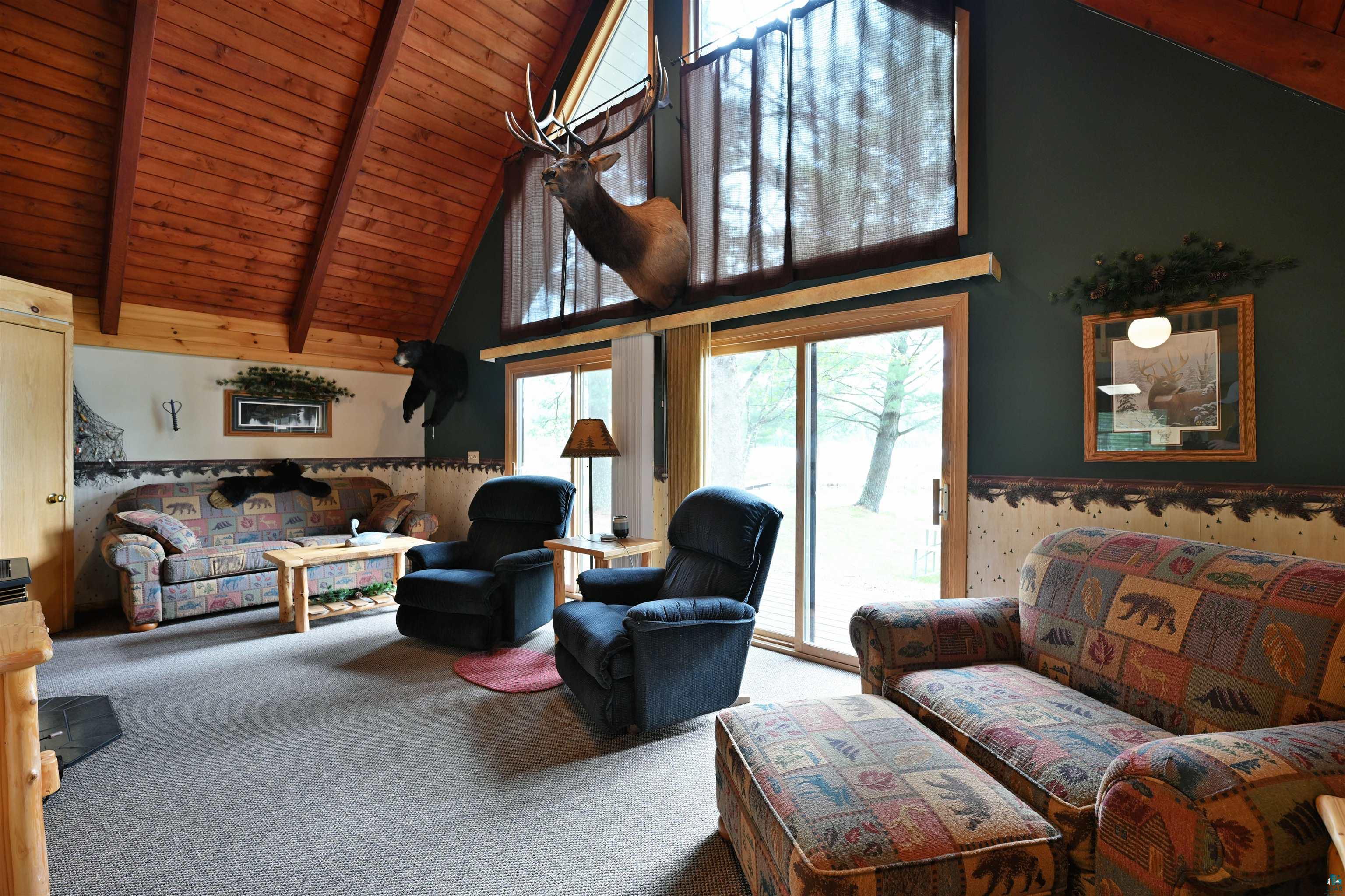 2775 Lake Road Barnes, WI 54873 - Photo 39 of 52 Living area featuring a high wooden beamed ceiling and carpet flooring