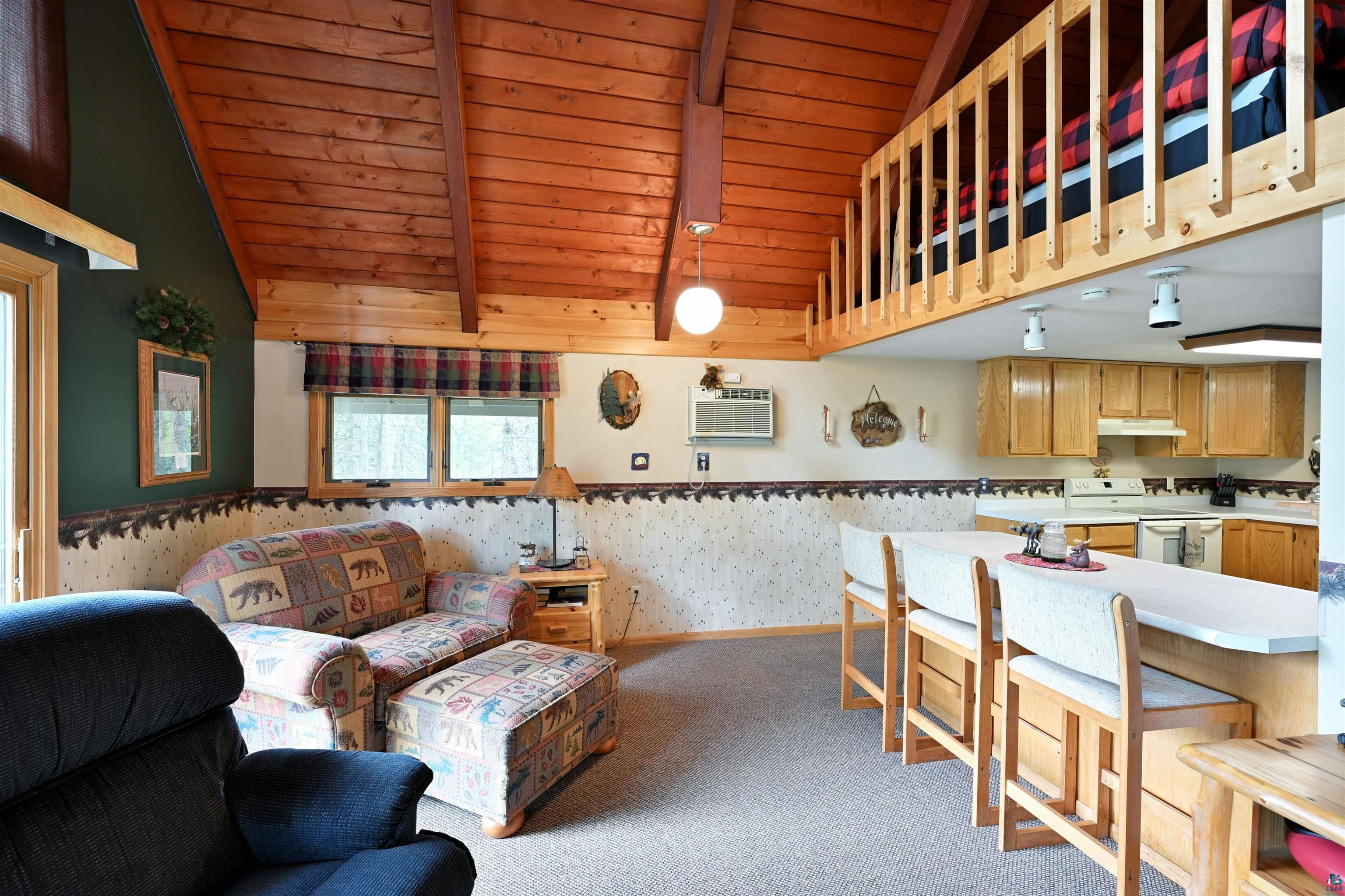 2775 Lake Road Barnes, WI 54873 - Photo 45 of 52 Living area with wallpapered walls, a high wood beamed ceiling, and light colored carpet