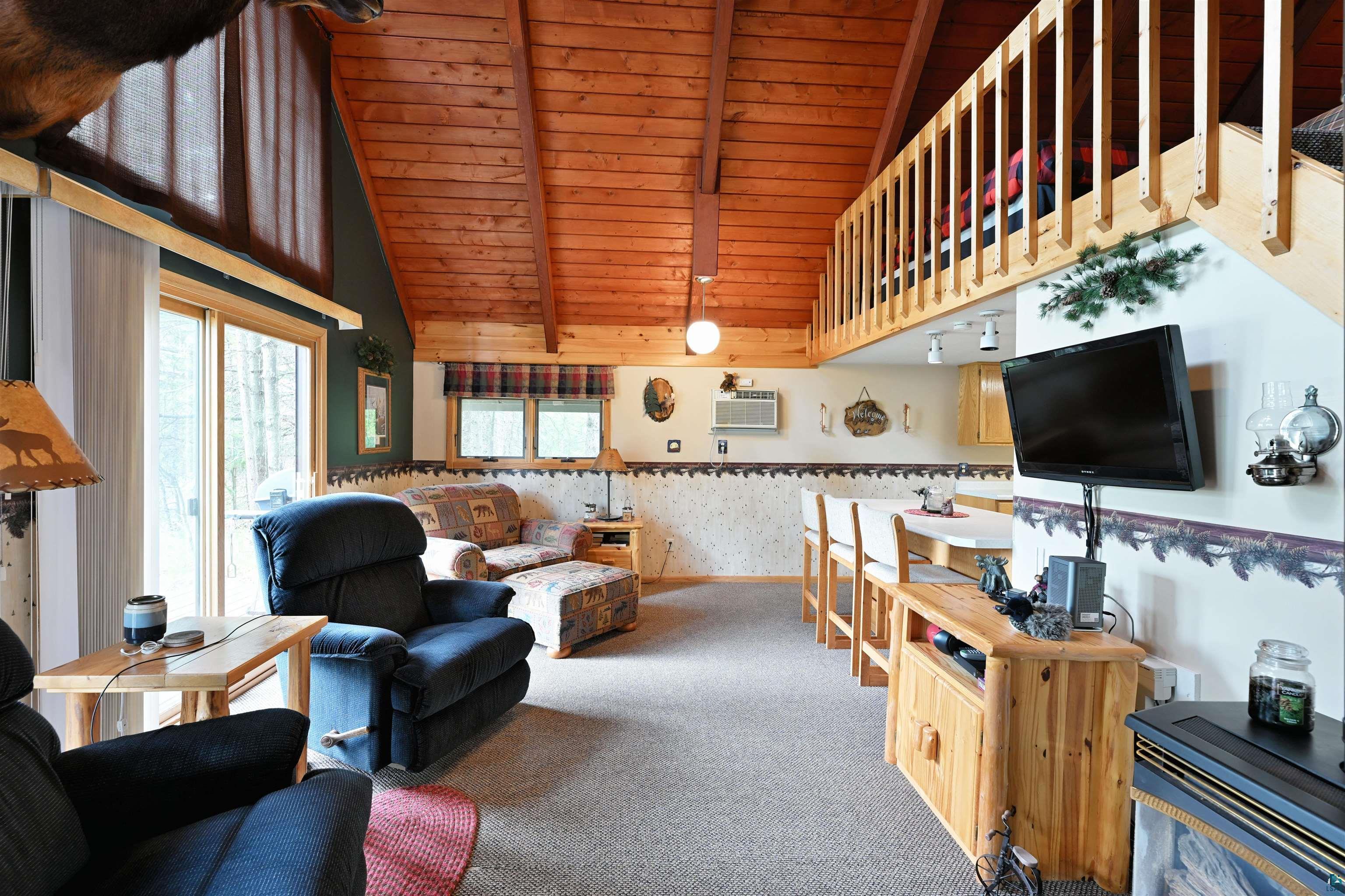 2775 Lake Road Barnes, WI 54873 - Photo 46 of 52 Living room with a high wooden beamed ceiling, carpet floors, and wallpapered walls