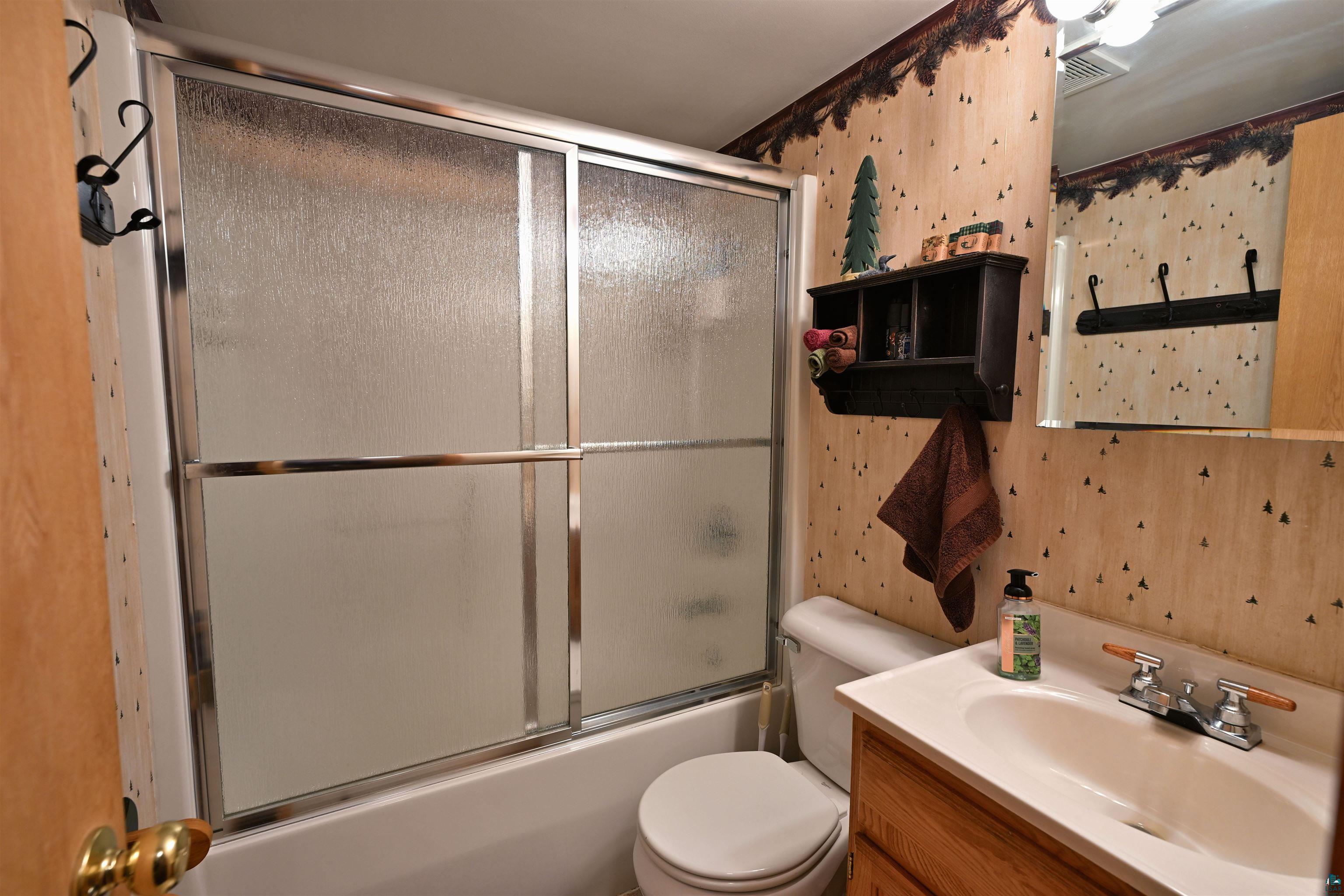 2775 Lake Road Barnes, WI 54873 - Photo 49 of 52 Bathroom featuring vanity and combined bath / shower with glass door