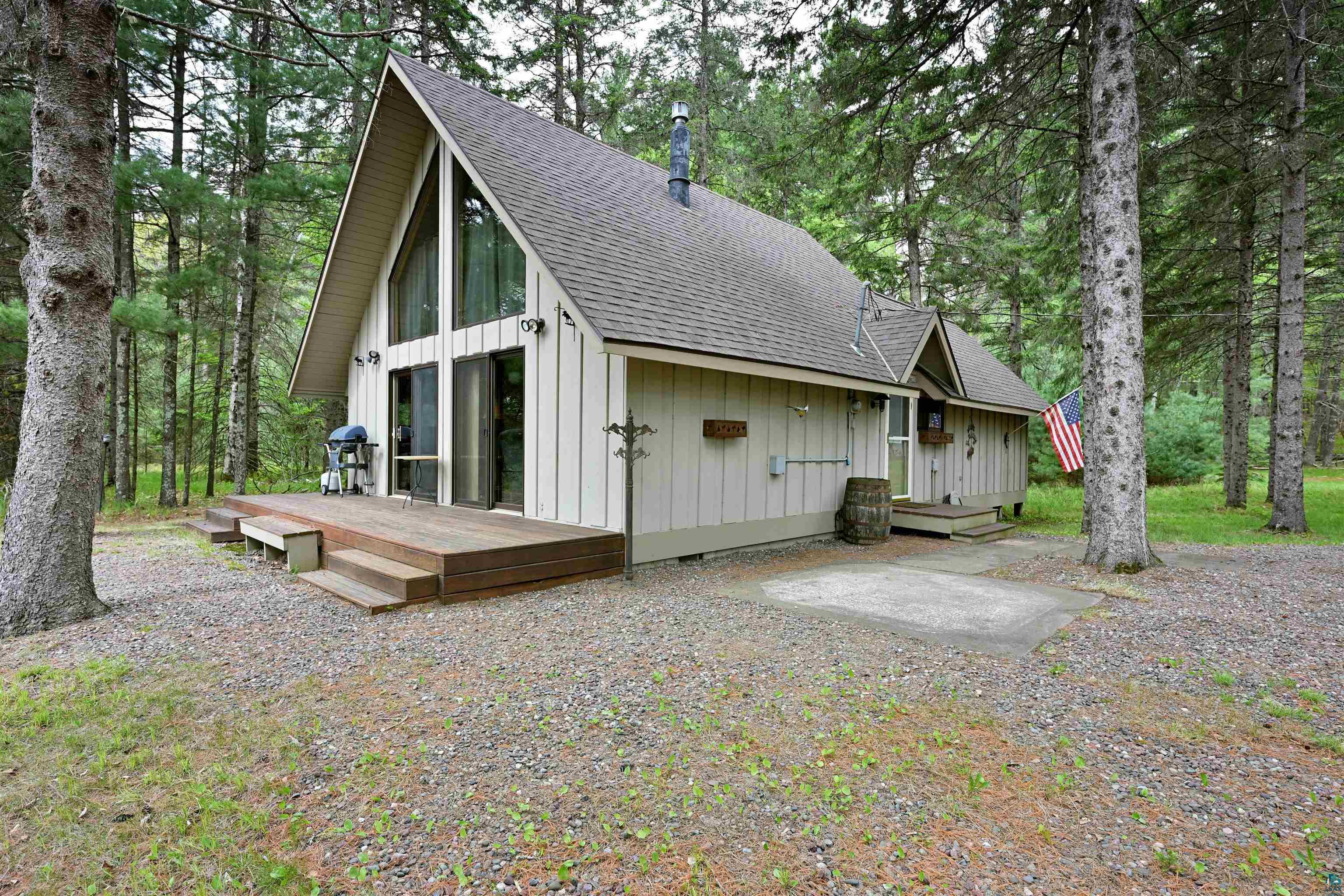 2775 Lake Road Barnes, WI 54873 - Photo 51 of 52 Rear view of house with a shingled roof, board and batten siding, a deck, and view of scattered trees