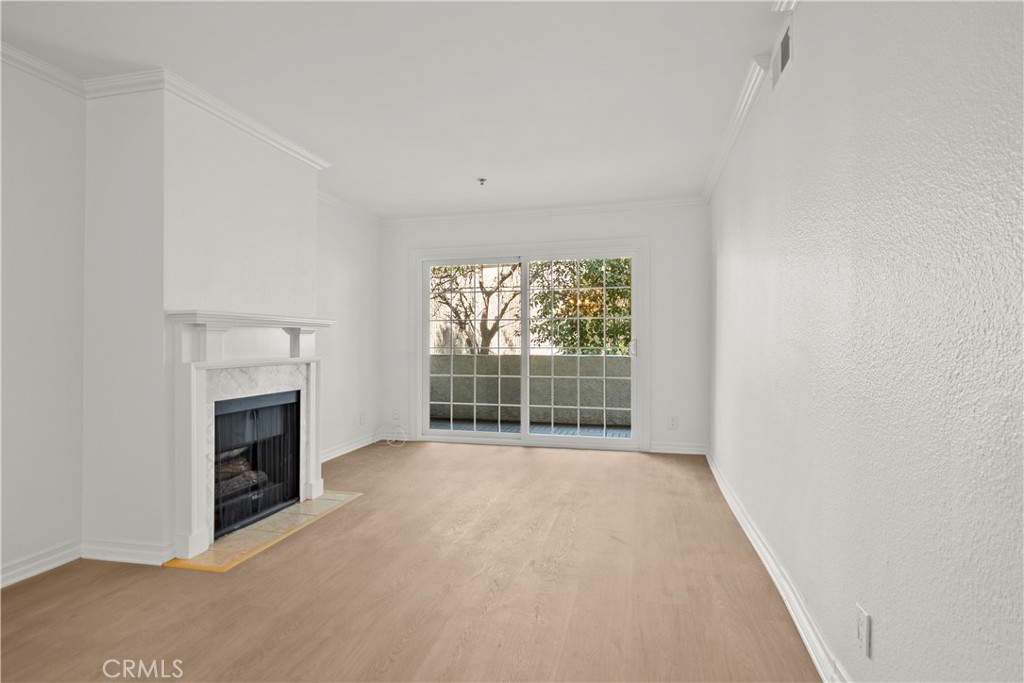 4401 Sepulveda Boulevard, Unit 107 Sherman Oaks, CA 91403 - Photo 13 of 25 an empty room with a fireplace and windows