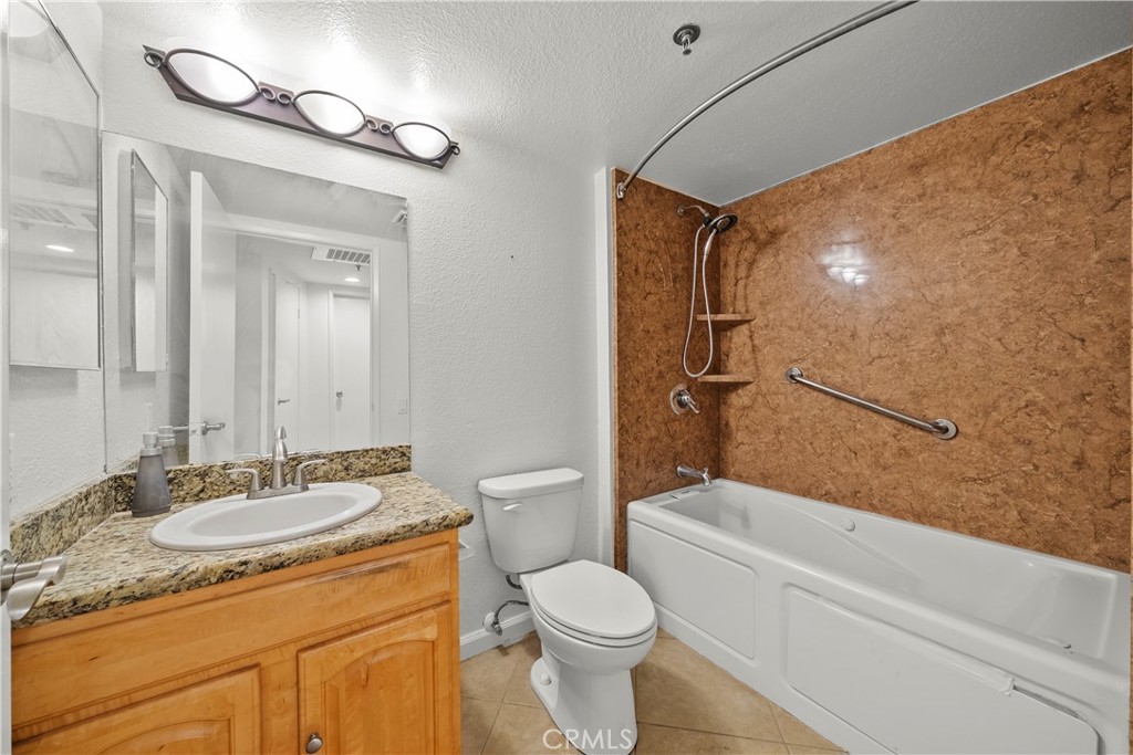 4401 Sepulveda Boulevard, Unit 107 Sherman Oaks, CA 91403 - Photo 21 of 25 a bathroom with a granite countertop sink toilet and shower