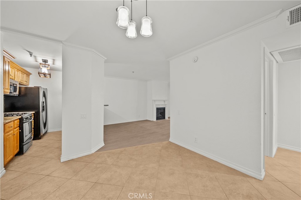 4401 Sepulveda Boulevard, Unit 107 Sherman Oaks, CA 91403 - Photo 4 of 25 en empty room with chandelier fan and kitchen view