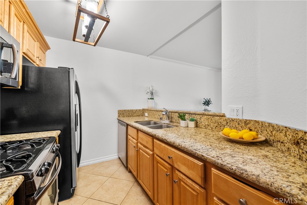 4401 Sepulveda Boulevard, Unit 107 Sherman Oaks, CA 91403 - Photo 8 of 25 a kitchen with stainless steel appliances granite countertop a sink stove and refrigerator