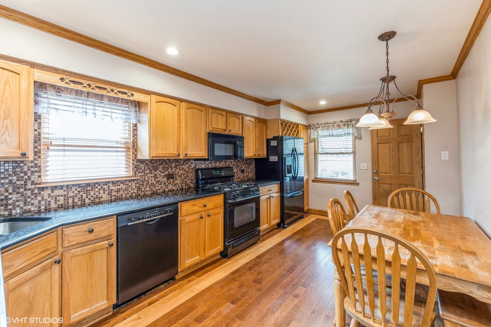2426 Lathrop Avenue North Riverside, IL 60546 - Photo 3 of 12 a large kitchen with stainless steel appliances granite countertop a stove a sink dishwasher a dining table and chairs with wooden floor