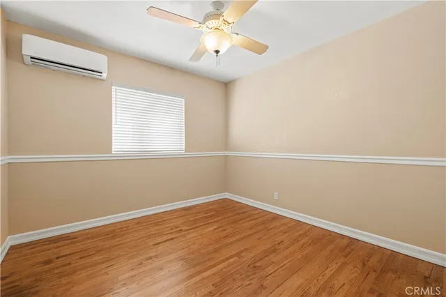 an empty room with a window and wooden floor